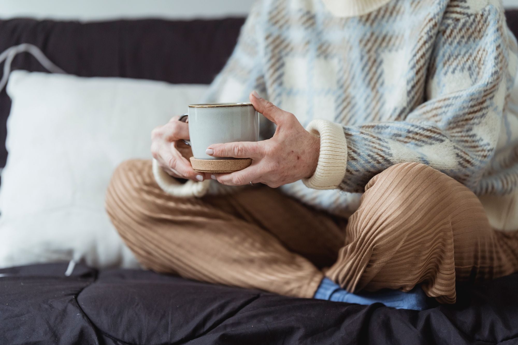 Woman resting on the sofa with a warm drink